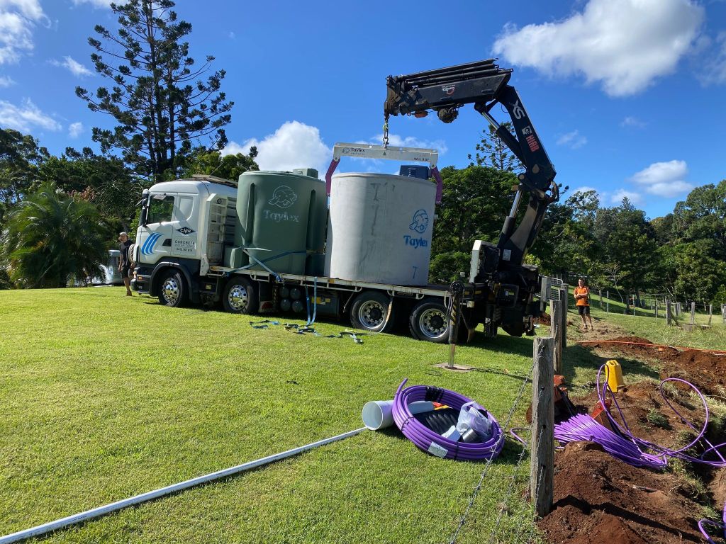 crane truck delivering septic tanks for installation