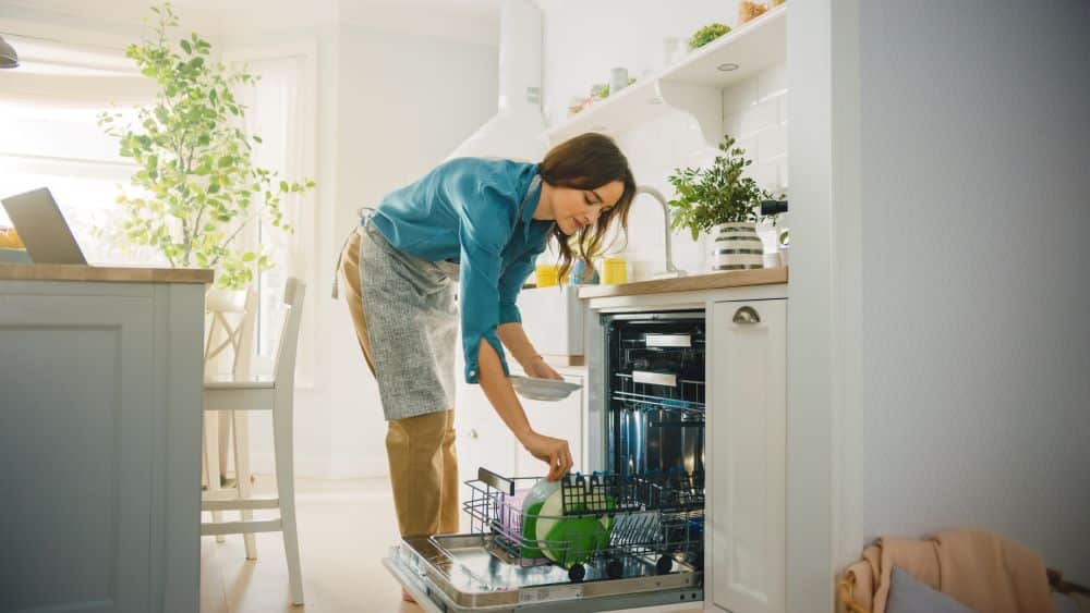 woman stacking a water saving fixture dishwasher