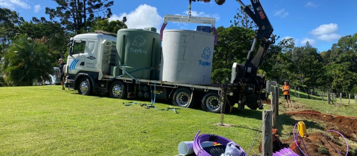 crane truck delivering septic tanks for installation